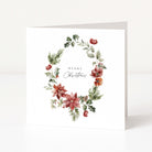 A square white Christmas greeting card standing upright, featuring a watercolour floral wreath with poinsettias, holly, and greenery, plus the words “Merry Christmas” in the centre.
