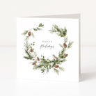 A square white greeting card with a watercolour-style holiday wreath featuring green pine branches, brown pinecones, and a small bird, with the words 'Happy Holidays' centred on a clean white background.