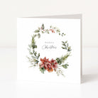 A square white Christmas greeting card standing upright, featuring a watercolour floral wreath with green leaves, red berries, and poinsettia-style flowers, with the words 'Happy Christmas' printed in the centre.