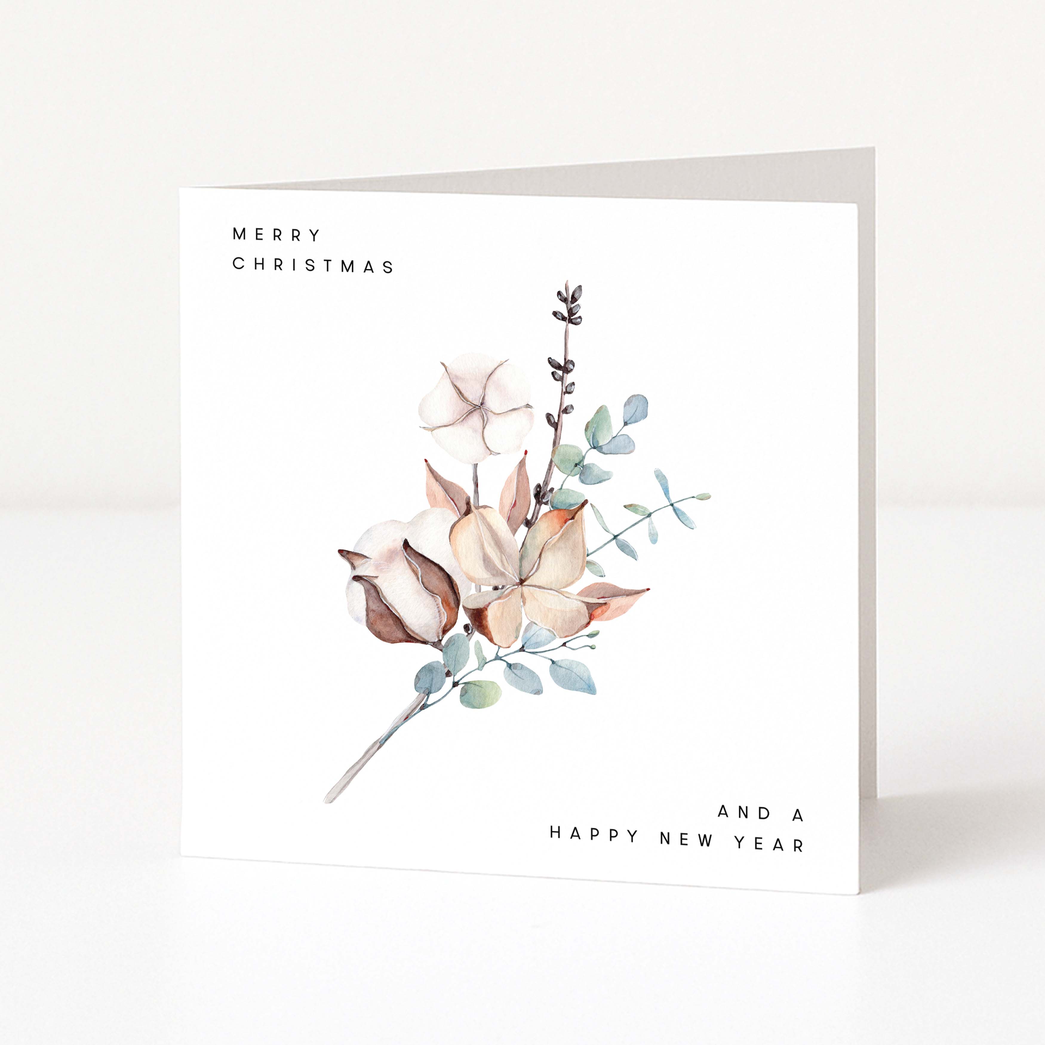 A square white greeting card with a watercolour floral illustration in soft beige, blush, green, and brown tones. The card reads 'MERRY CHRISTMAS' at the top left and 'AND A HAPPY NEW YEAR' at the bottom right, photographed standing against a clean white background.