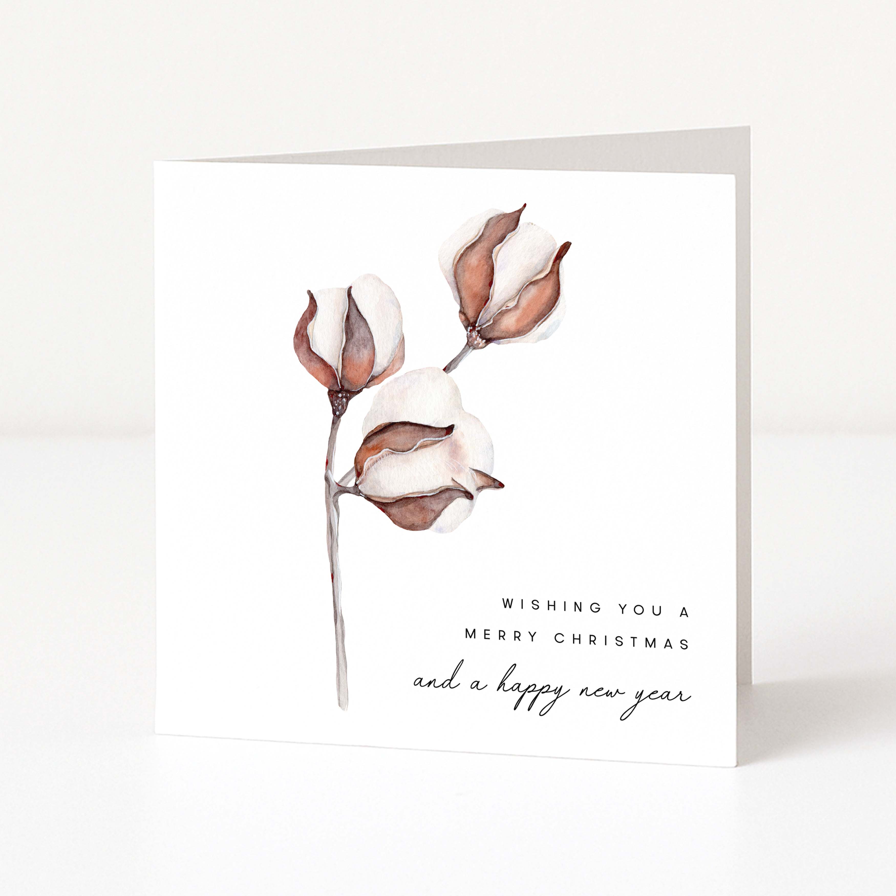 A square white greeting card standing upright, printed with a watercolour-style botanical illustration of cotton buds and the text 'Wishing you a Merry Christmas and a happy new year' on a clean white background.