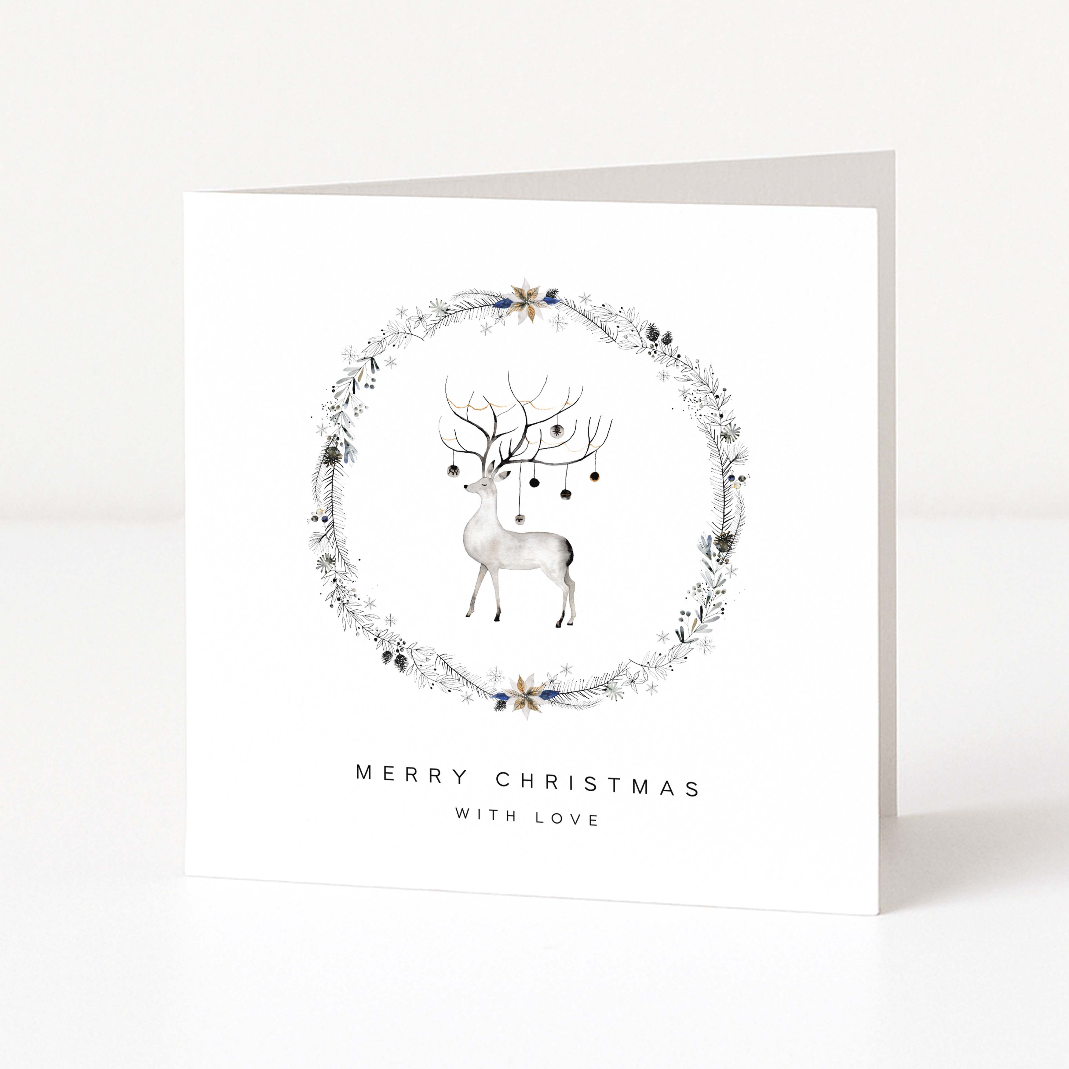 A square white Christmas greeting card standing upright on a light grey surface. The front features a watercolour-style grey deer centred within a delicate floral wreath, with the text 'MERRY CHRISTMAS WITH LOVE' printed below in black.