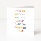 A white anti-Christmas card standing upright on a white surface, printed with the punny phrase 'IF YOU ASK ME TO PUT AN ELF ON A SHELF I'LL HIT THE TWAT WITH A BAT' in colorful pastel letters.