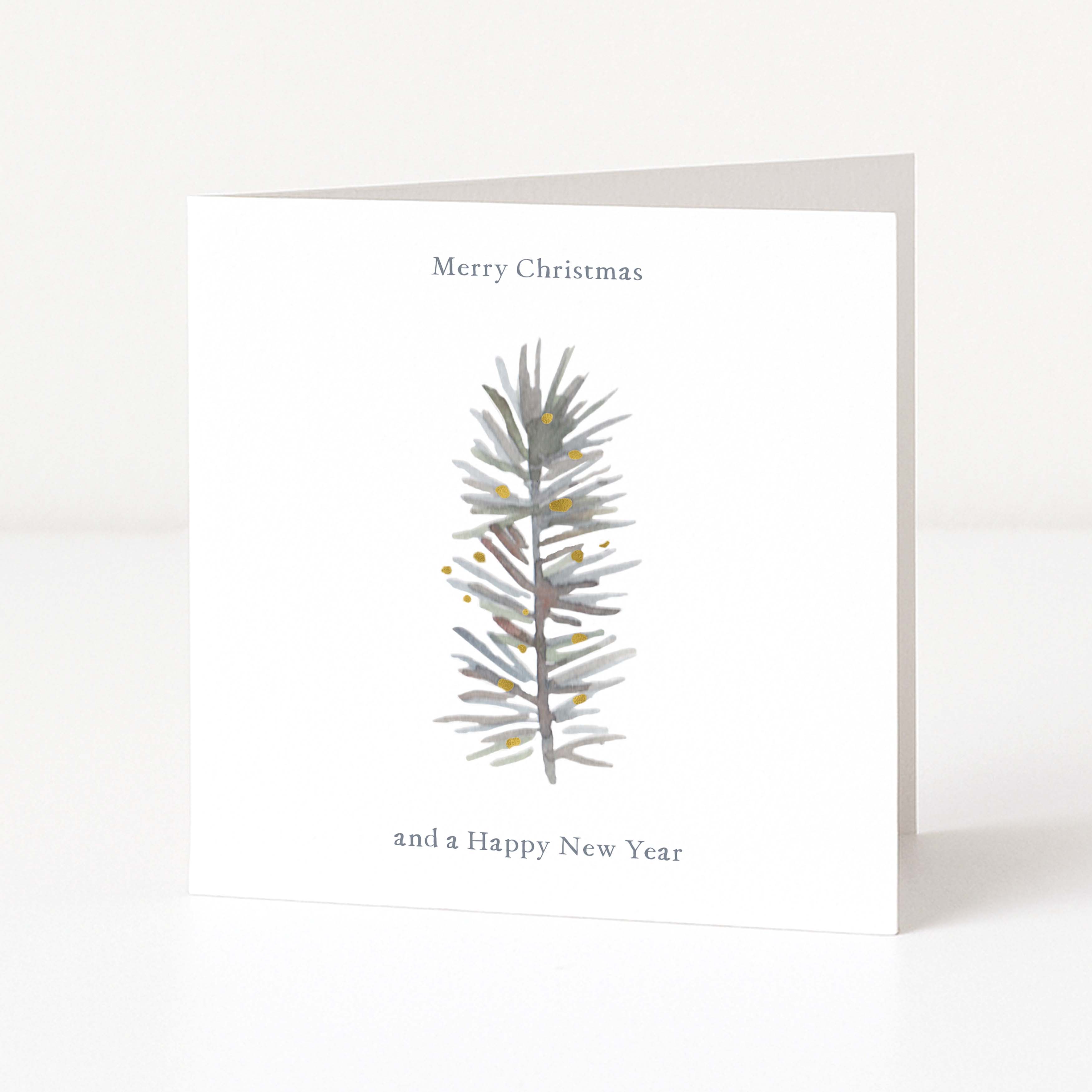 A minimalist white Christmas greeting card standing upright on a white surface, featuring a watercolour-style grey pine branch with small gold dots and the text 'Merry Christmas and a Happy New Year'.