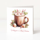 A square Christmas greeting card featuring an illustration of a hot chocolate mug topped with whipped cream, candy canes, holly leaves, and marshmallows, with the text 'Wishing you a Merry Christmas' in red script at the bottom.