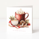A square Christmas greeting card featuring a watercolour illustration of a red mug filled with marshmallows and hot chocolate, alongside a cup of tea, cinnamon sticks, and chocolate squares on a red plaid cloth. The card reads 'eat, drink and be merry' at the bottom, shown standing upright against a clean white background.