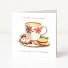 A square white Christmas greeting card standing upright, printed with the phrase 'Cosy nights and warm hearts' at the top and 'Wishing you a very Merry Christmas' at the bottom. The center shows an illustrated white mug with red snowflake patterns, filled with a warm drink, alongside a small decorated pastry, cookies, and greenery on a plate.
