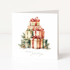 A white square Christmas greeting card standing upright, featuring a watercolour illustration of stacked gift boxes wrapped in red, green, and beige paper with bows, plus small evergreen sprigs and berries. The card reads 'season's greetings' in a delicate script at the bottom.