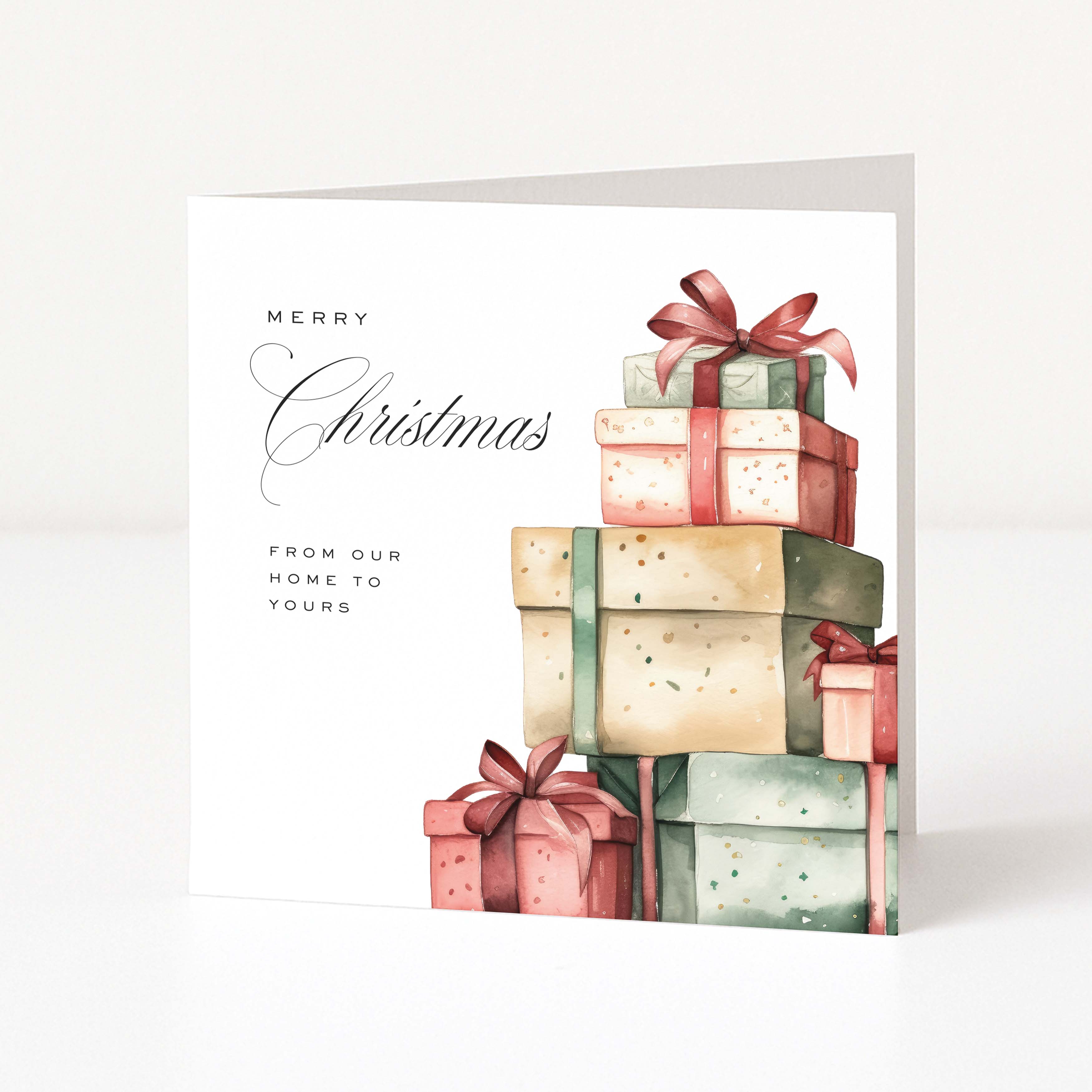 A square Christmas greeting card with a white background, featuring the text 'Merry Christmas from our home to yours' and an illustration of stacked gift boxes in soft pastel tones with red ribbons, shown standing upright on a light surface.