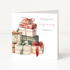 A square Christmas greeting card standing upright on a white surface. The card features an illustration of stacked gift boxes in muted red, green, beige, and brown tones, with the text 'Wishing you a very merry Christmas' printed on the right side.