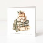 A square greeting card with a white background featuring a watercolour illustration of a stack of wrapped Christmas presents and a green scarf. The card reads 'IT'S THE MOST WONDERFUL TIME OF THE YEAR' at the bottom.