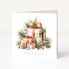 A square white Christmas greeting card standing upright, printed with a watercolour-style illustration of wrapped gift boxes, candles, pine branches, and the text 'Merry Christmas' at the bottom.