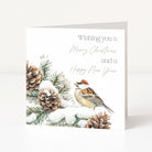 A square white greeting card standing upright on a light grey surface. The card features an illustration of a small house sparrow perched among snowy pine branches and pinecones, with the text 'Wishing you a Merry Christmas and a Happy New Year' in dark grey and pale sage lettering.