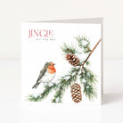 A square greeting card standing upright on a white surface against a light neutral background. The card features the text 'JINGIE ALL THE WAY' above an illustration of a robin perched on a snow-dusted pine branch with pinecones.