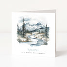 A white Christmas greeting card standing upright on a white surface, featuring a watercolor winter landscape with mountains, trees, and a winding river. The text at the bottom reads “WALKING IN A WINTER WONDERLAND.