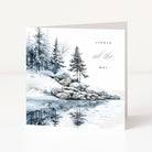 A square Christmas greeting card with a winter landscape illustration, featuring snow-covered rocks, evergreen trees, and a reflective icy surface. The card reads 'JINGLE all the WAY' in black and blue-gray text.
