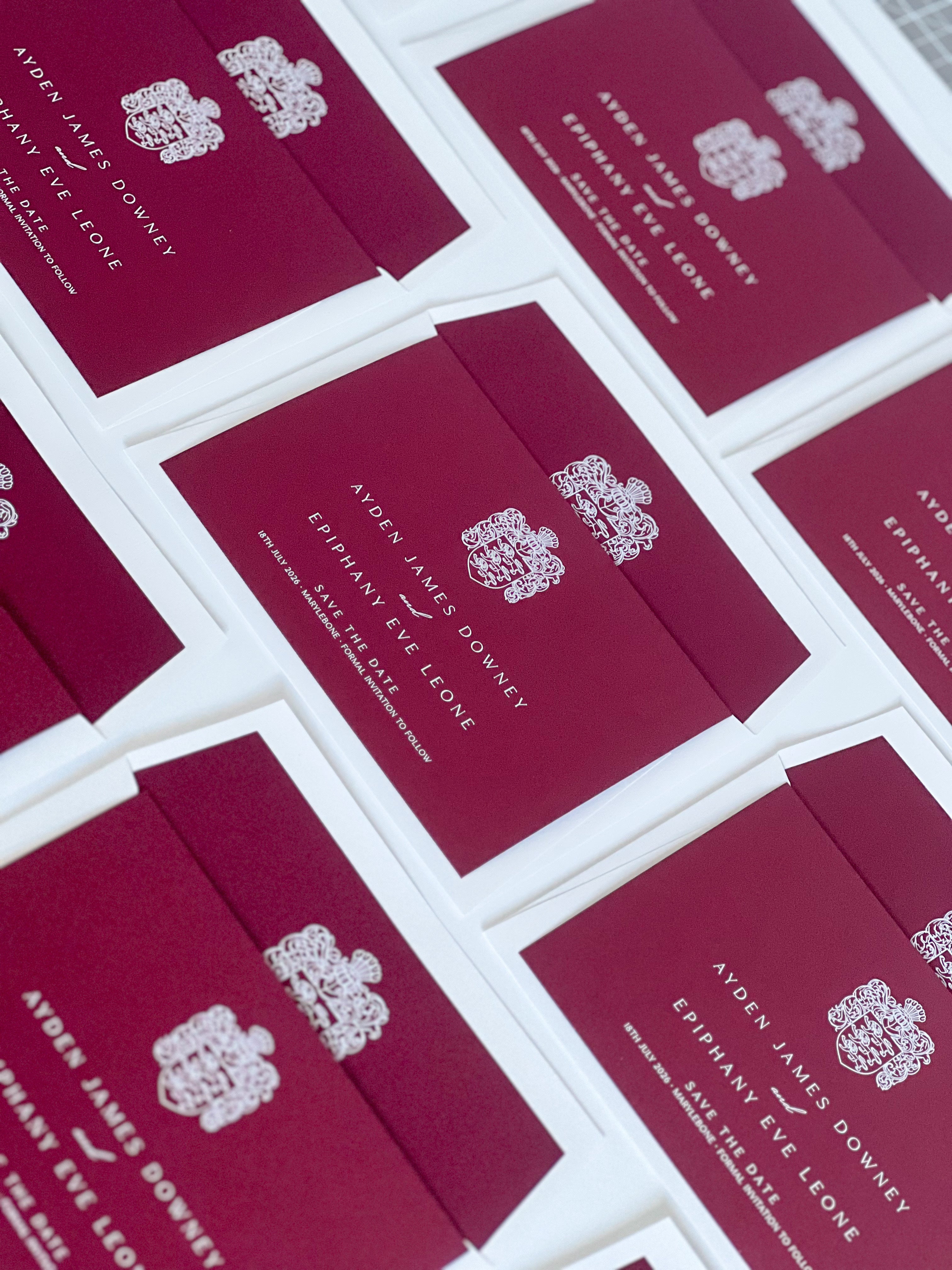 Burgundy and white ink save the date cards with custom crest
