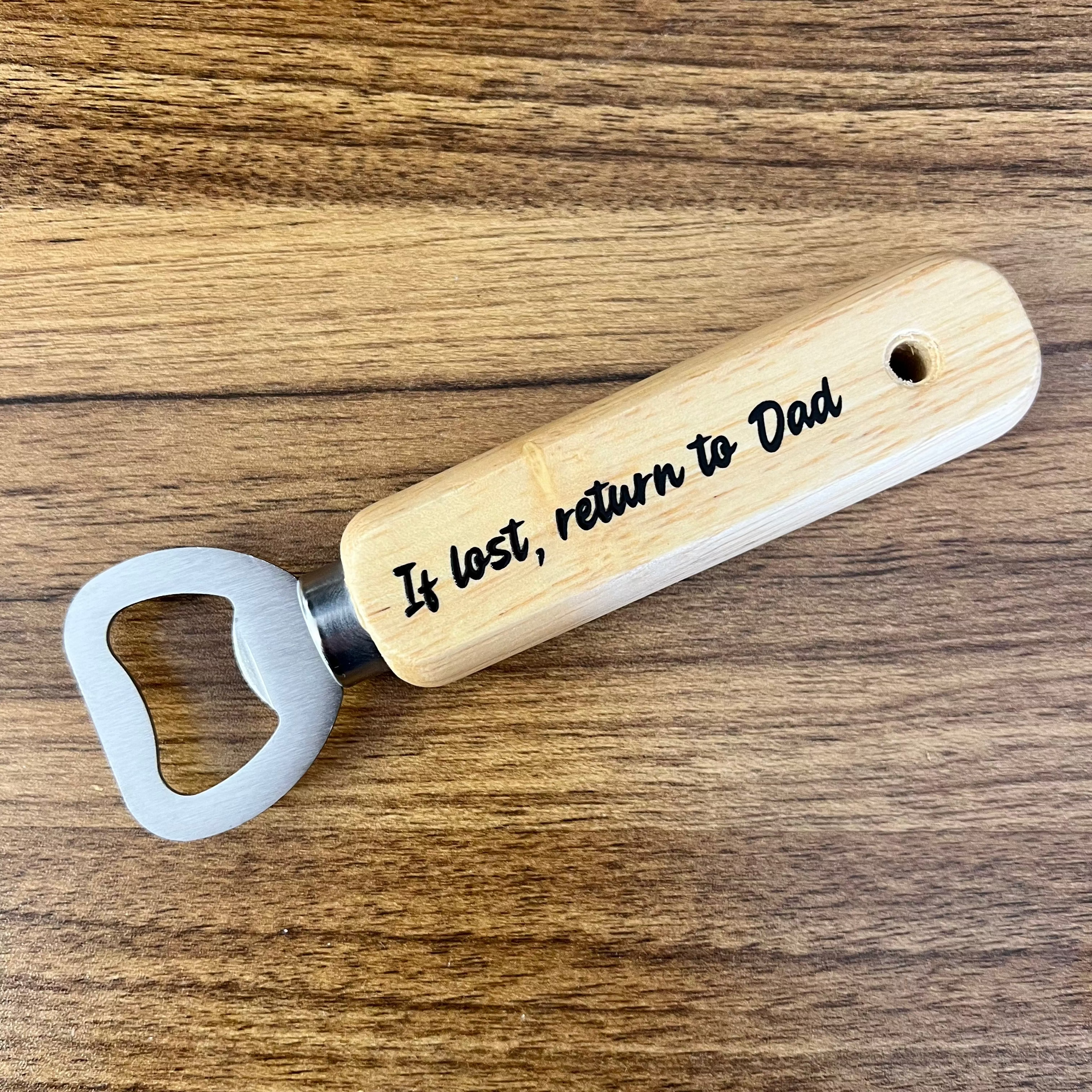 Wooden bottle opener with engraved text on a wooden surface