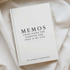 A hardcover book titled 'MEMOS FROM INSIDE THE DUMSTER FIRE THAT IS MY LIFE' by Harriet Goulding, placed on draped cream-colored fabric.