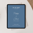 A tablet displaying a blue wedding save-the-date with white text, styled on top of white envelopes on a light beige surface.