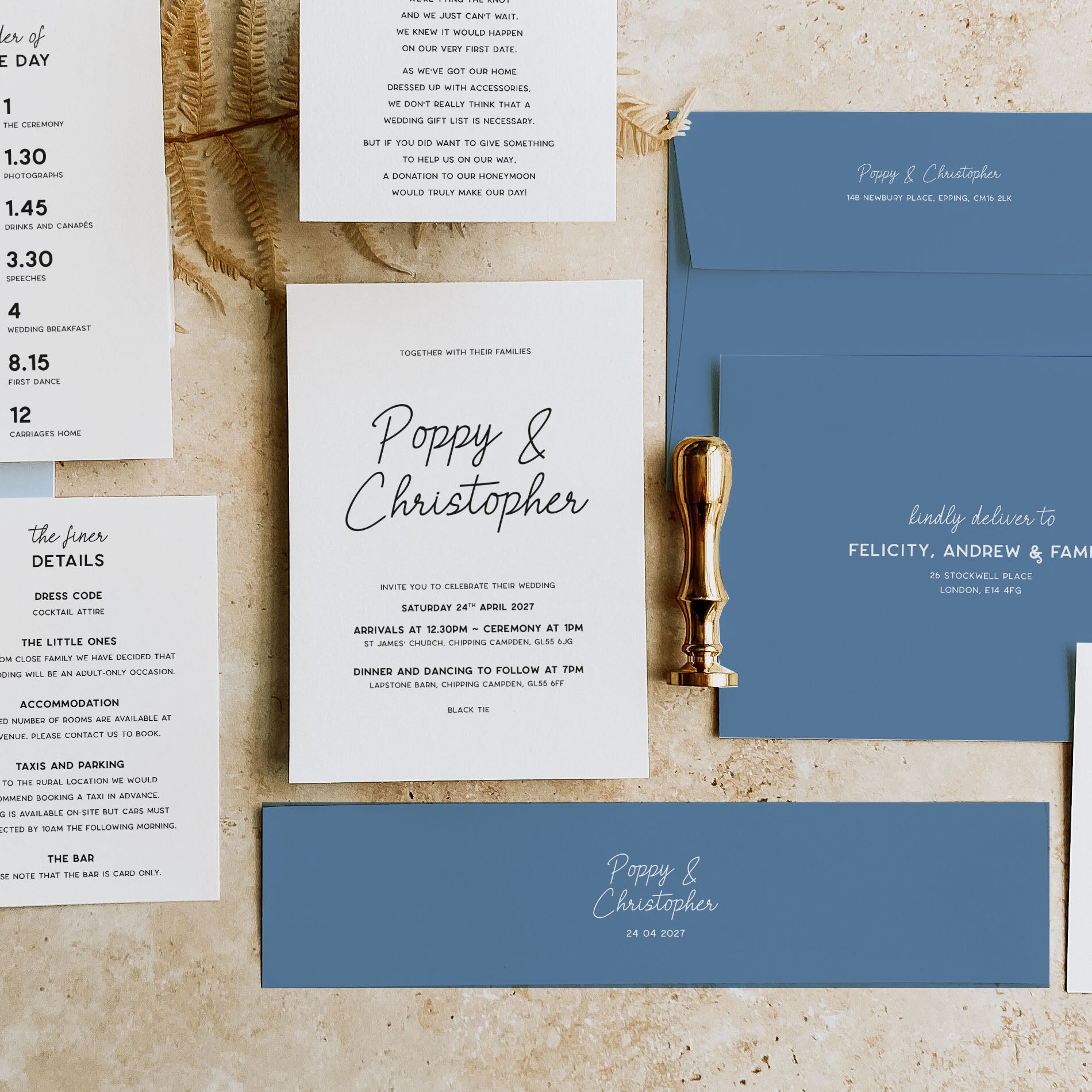 A styled flat-lay of a wedding invitation suite on a textured beige fabric background. The set includes a blue envelope, a white invitation card with black script reading 'Poppy & Christopher', smaller white detail cards with event text, and a gold pocket watch as a decorative prop.