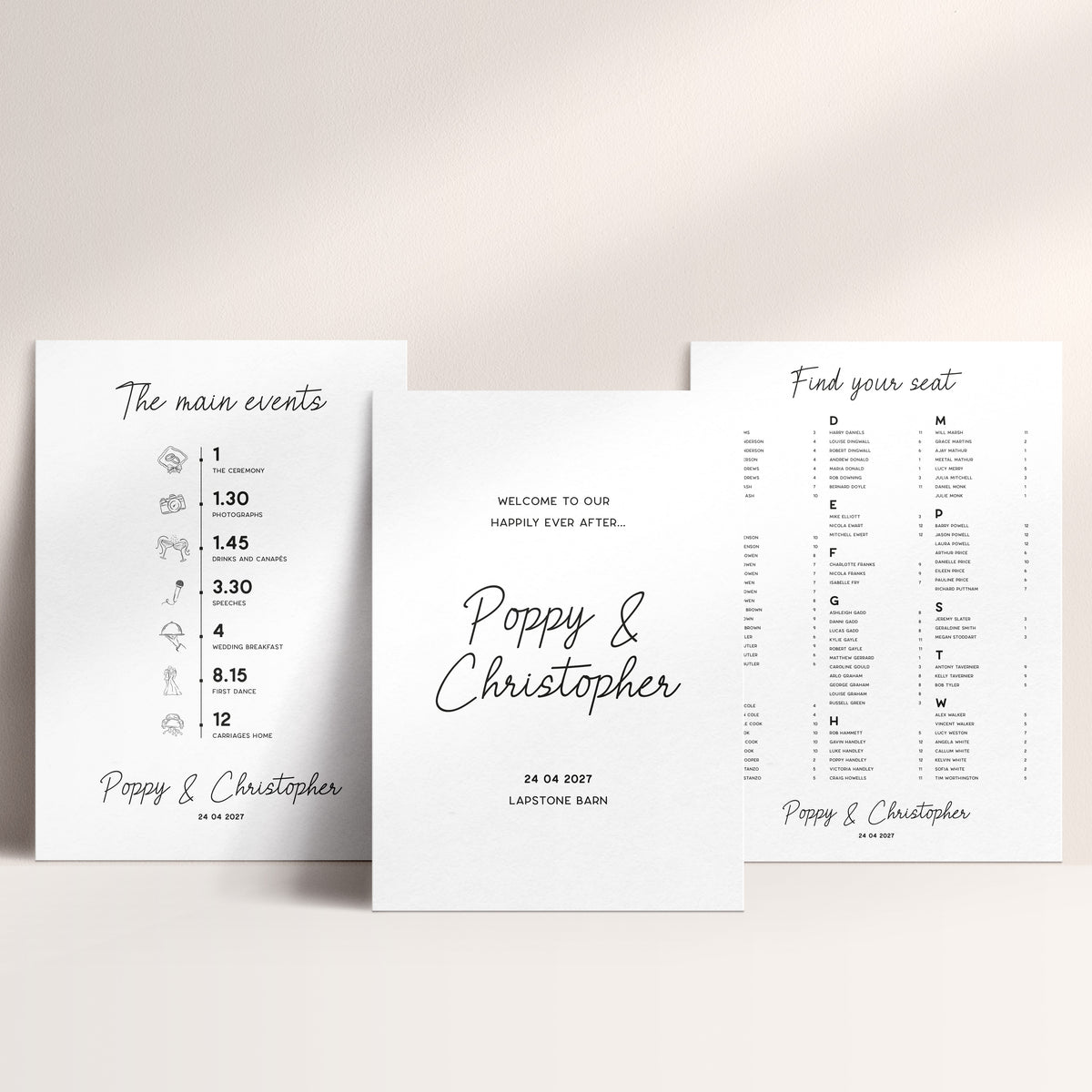 Three white wedding signs arranged on a light beige background. The centre sign reads 'Welcome to our happily ever after.