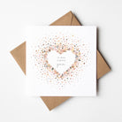 Greeting card with confetti heart design and brown envelope on white background