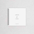 Spiral-bound notebook with 'Jasmine & Peter' and a date on a textured gray background