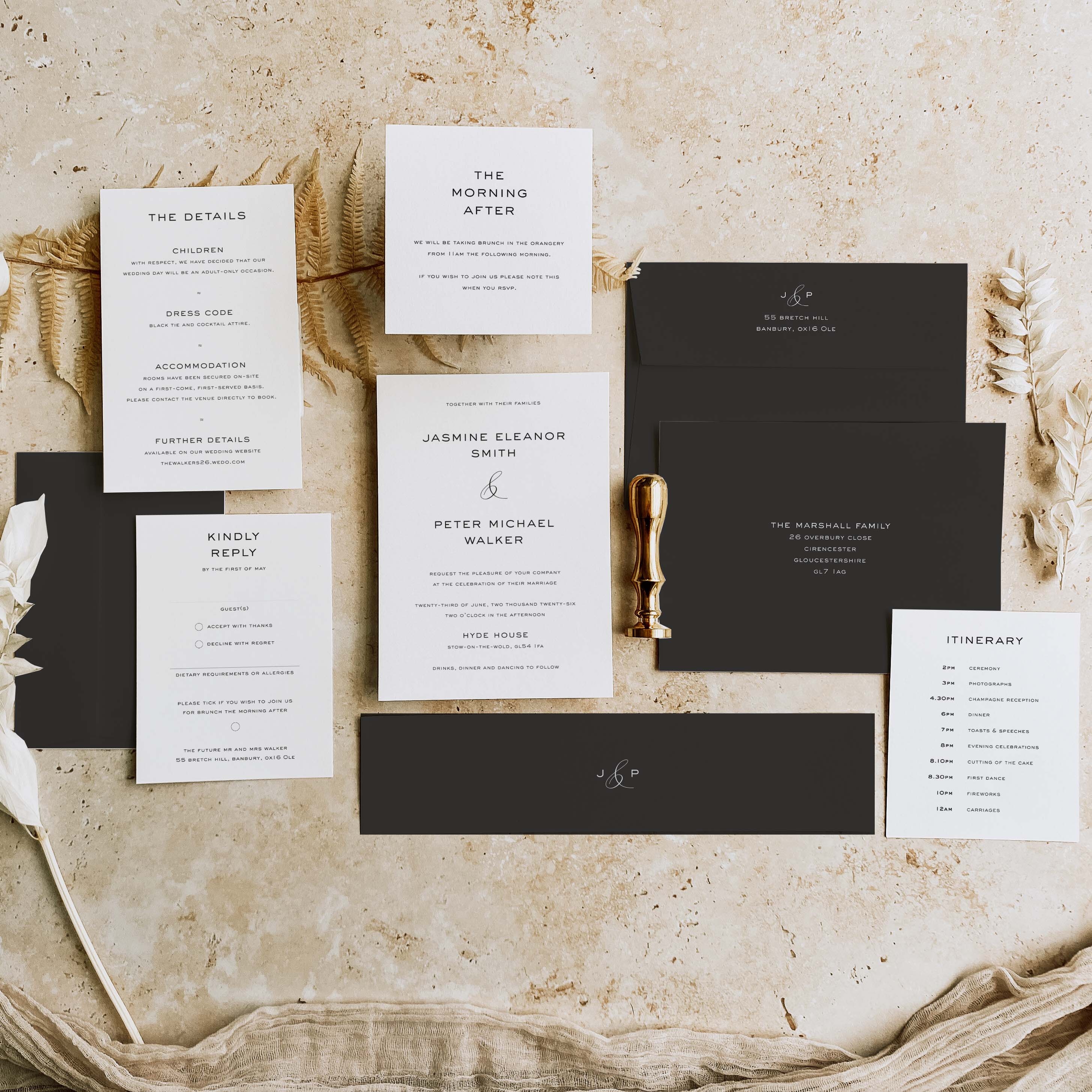 Wedding invitation suite with black and white cards on a textured surface