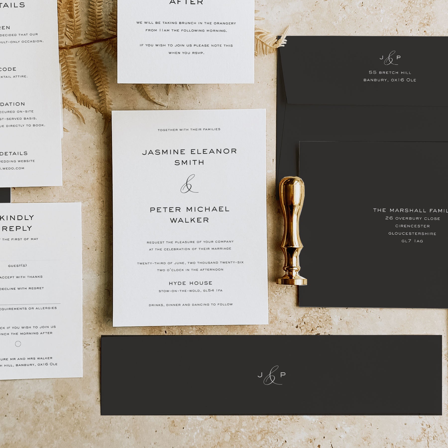 Wedding invitation set with RSVP card and gold wax seal on a textured surface