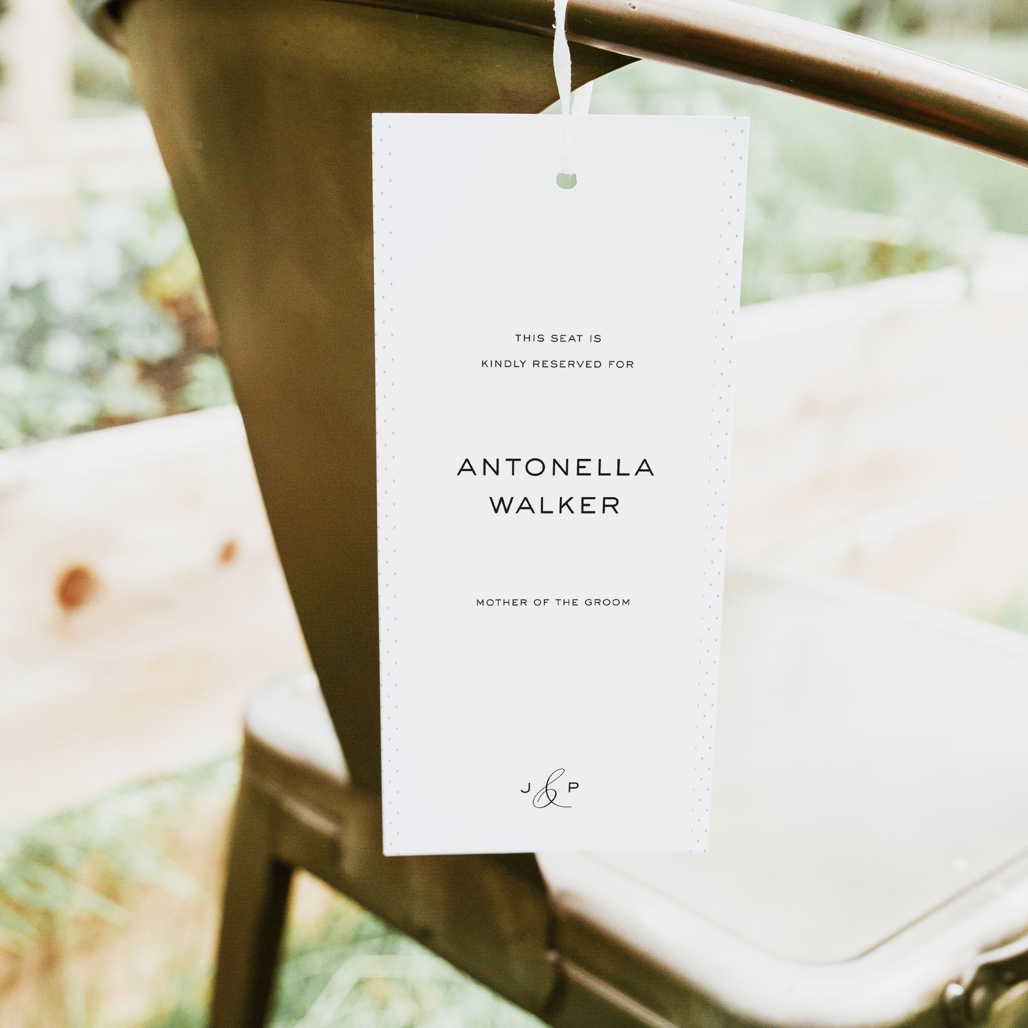 Reserved seat card for Antonella Walker on a blurred outdoor background