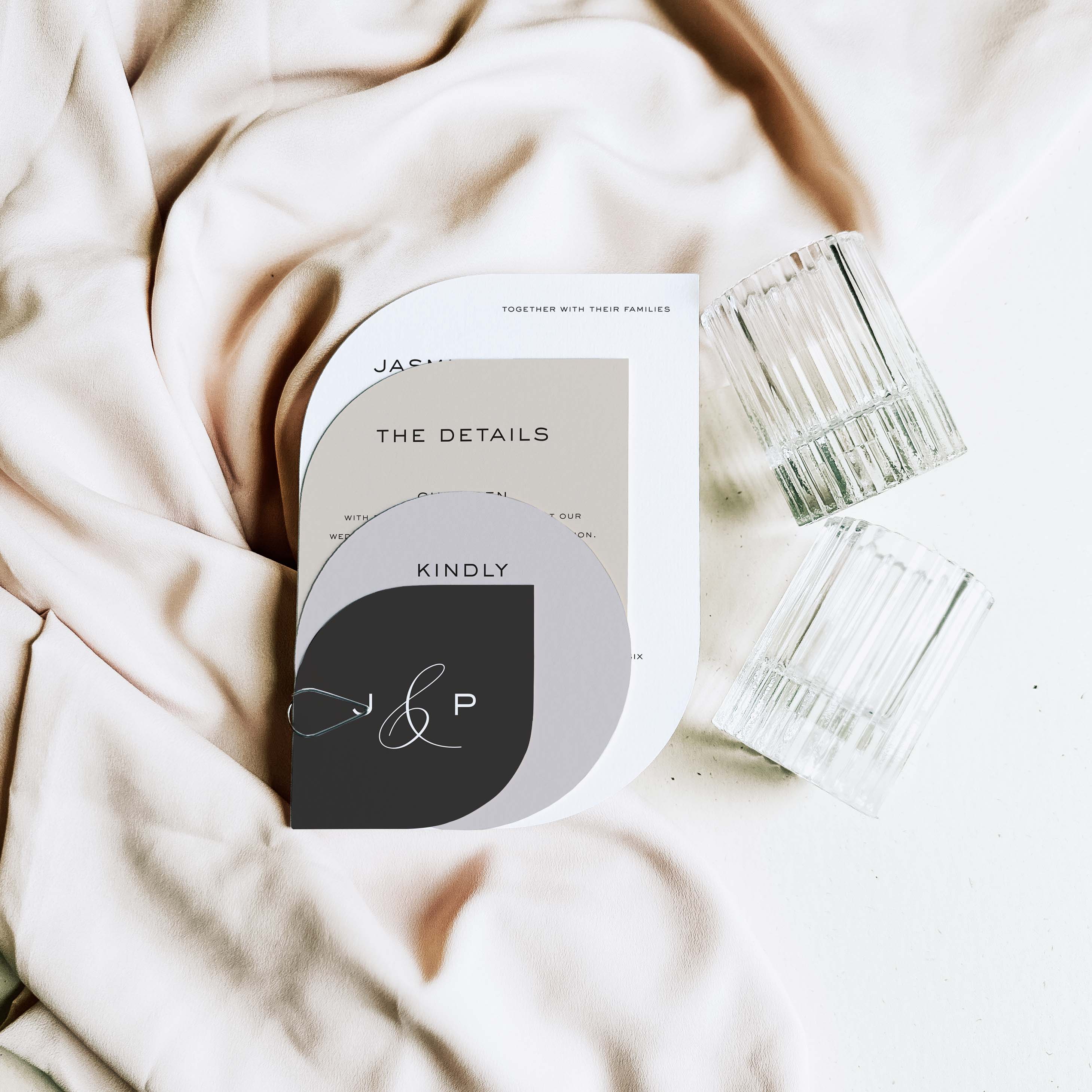 Shaped Wedding invitation set with 'J & P' on a soft fabric background