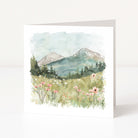 Greeting card with a mountain landscape and flowers on a white background