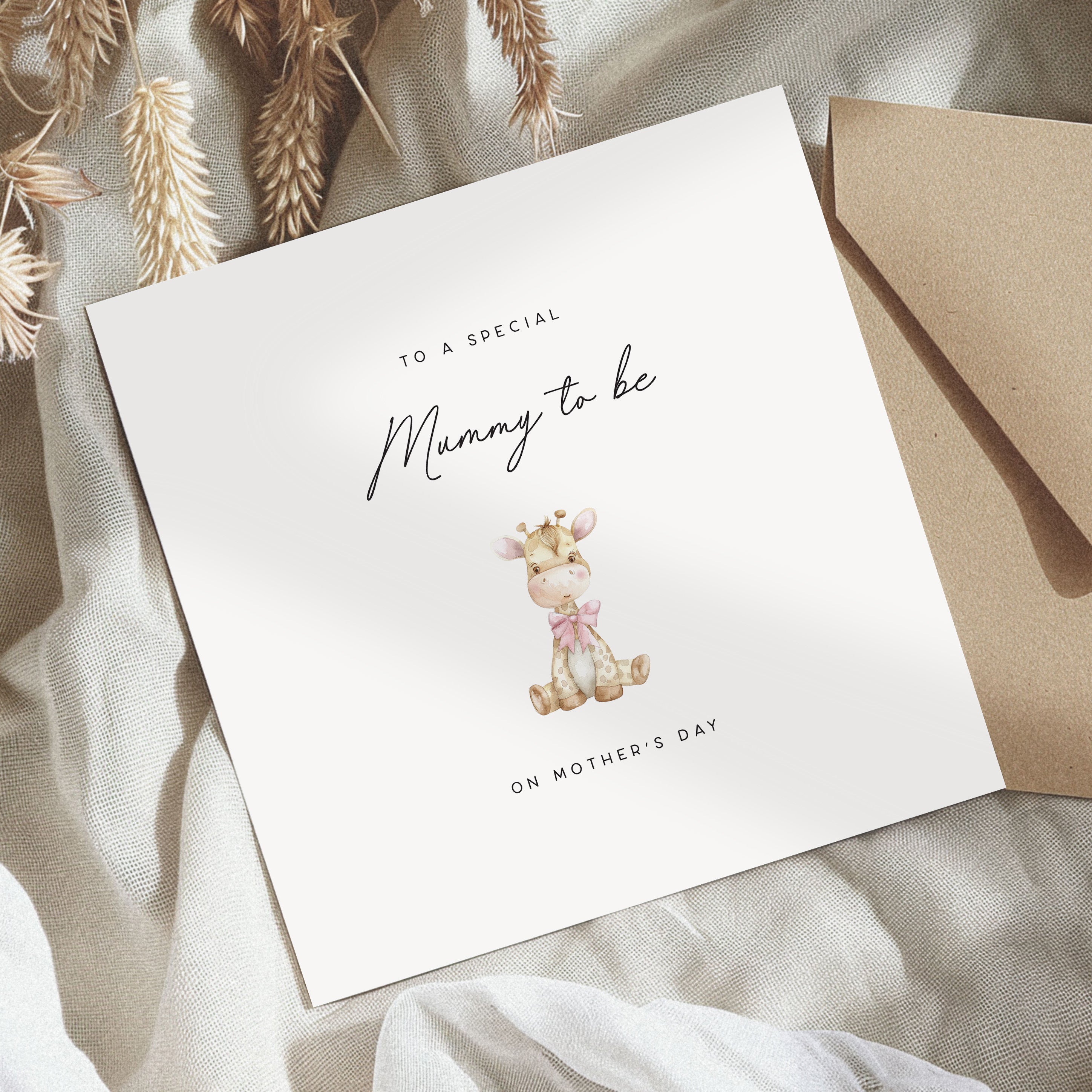 Greeting card for a special 'Mummy to be' on Mother's Day with a giraffe illustration, placed on a textured fabric background.