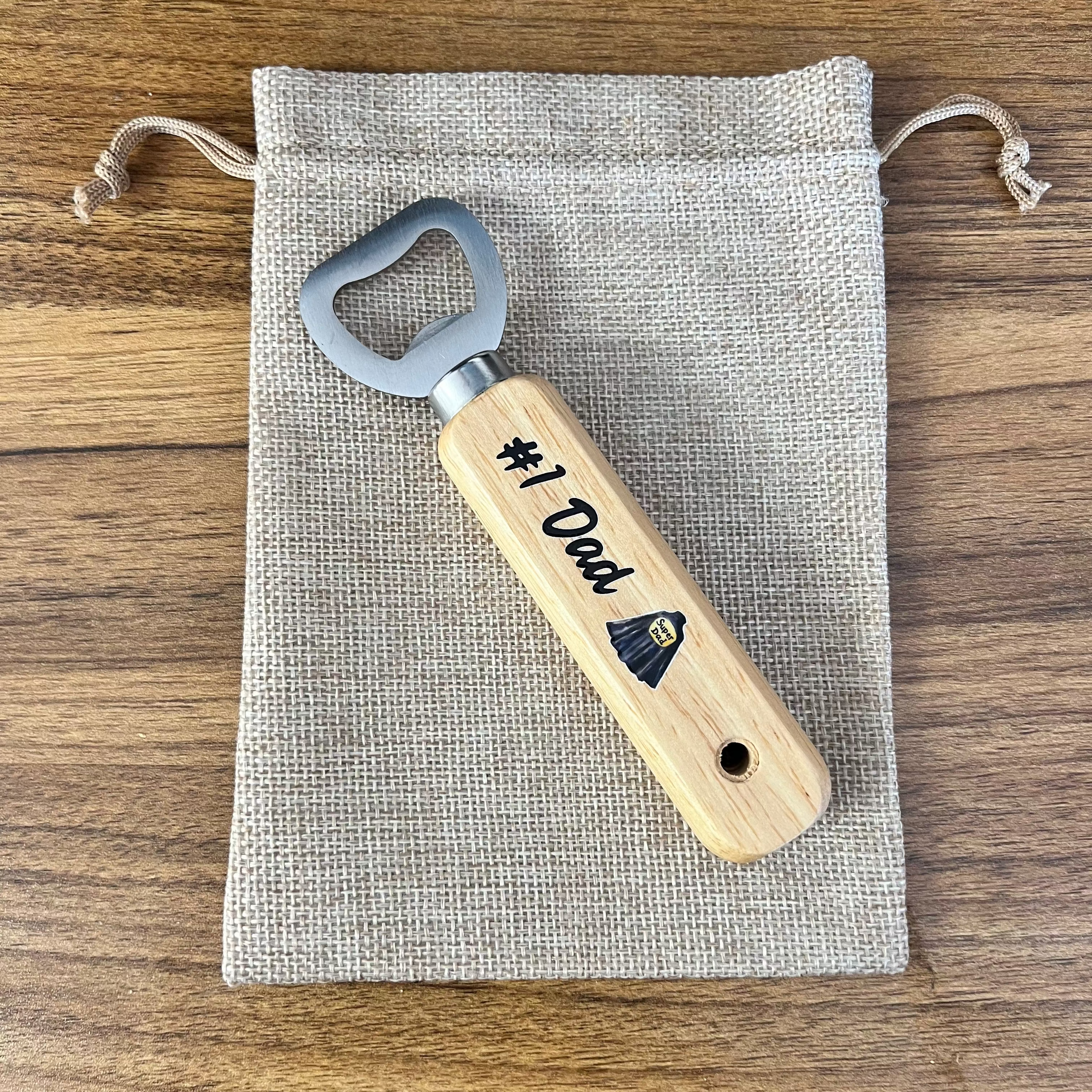 Wooden bottle opener with '#1 Dad' engraving on a fabric pouch
