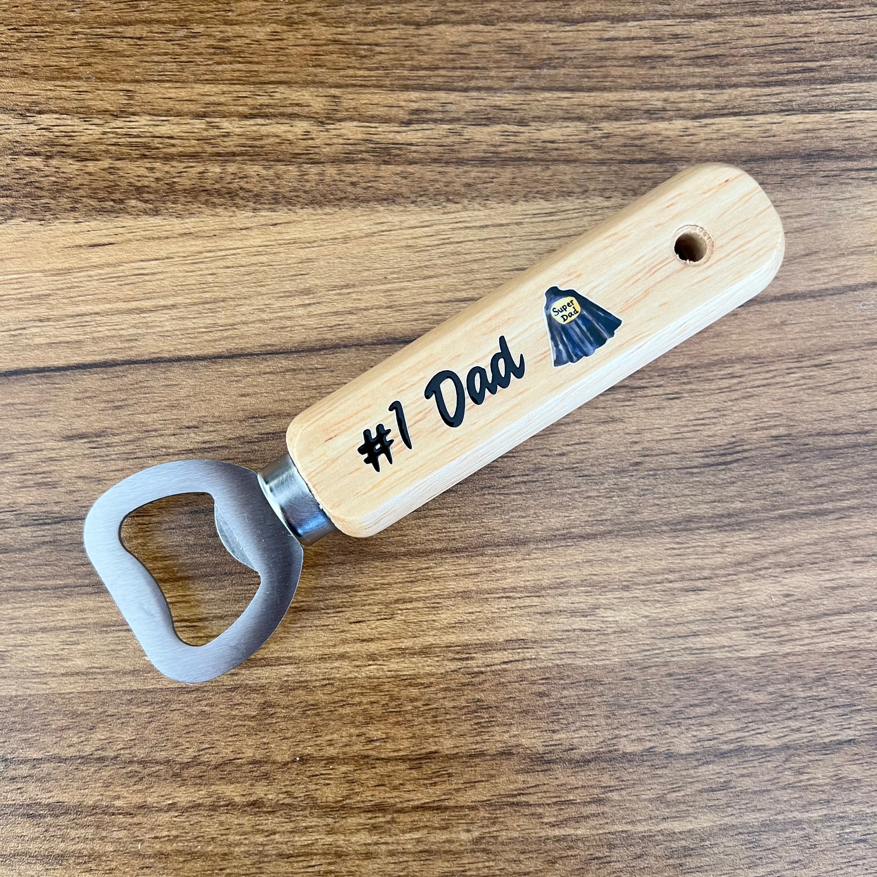 Wooden bottle opener with '#1 Dad' engraving on a wooden surface