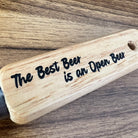 Wooden sign with 'The Best Beer is an Open Beer' text on a wooden surface