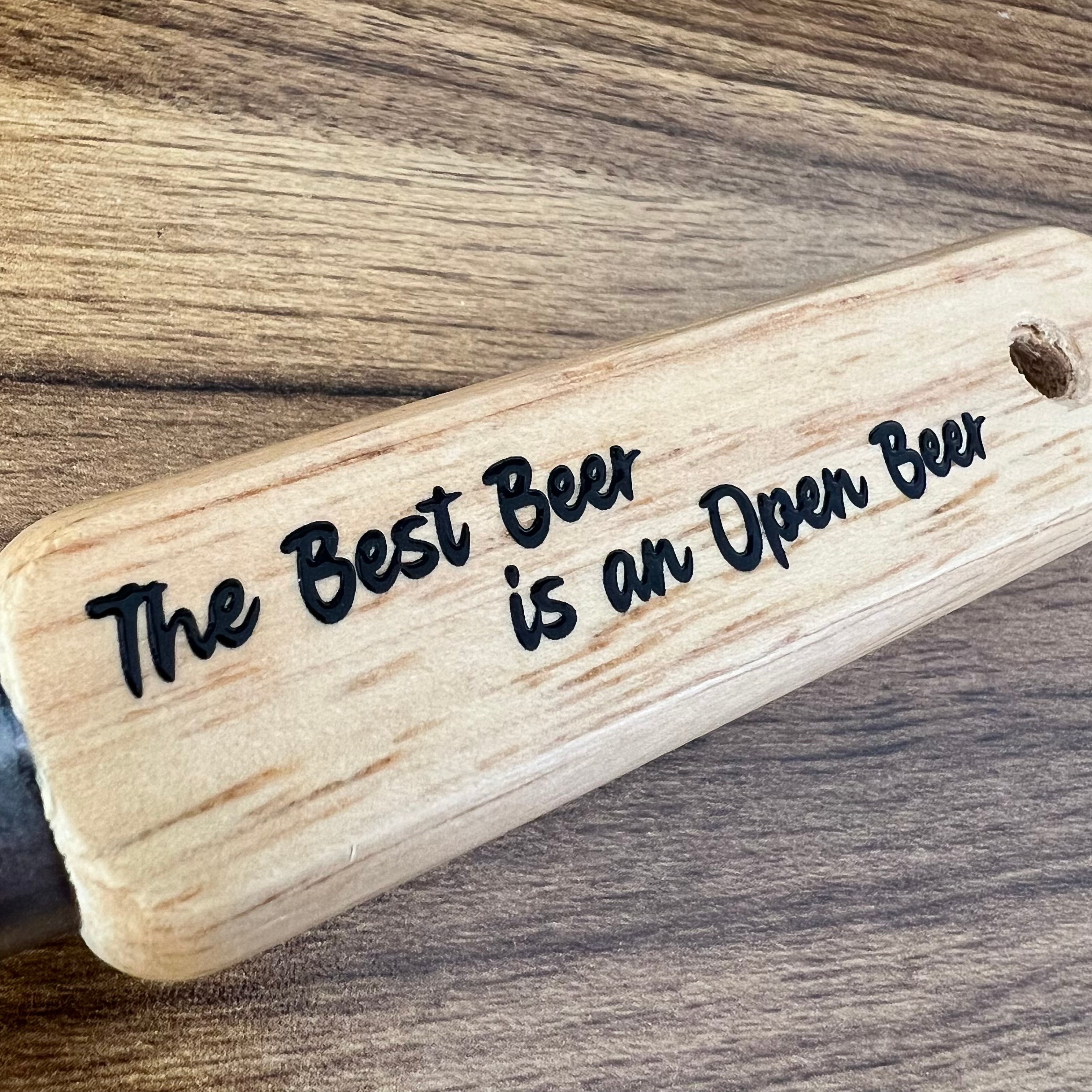 Wooden sign with 'The Best Beer is an Open Beer' text on a wooden surface