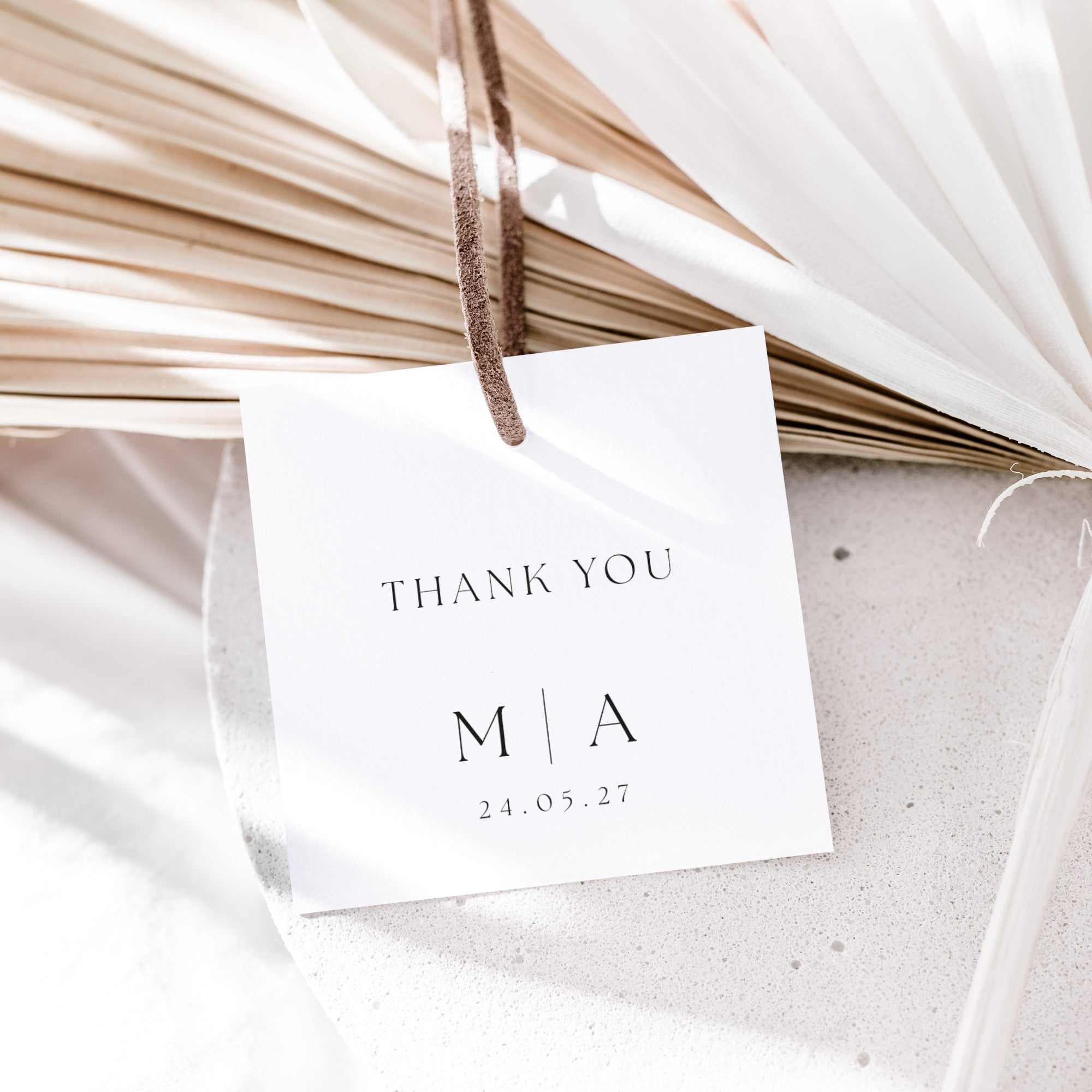White card with 'THANK YOU' and initials, hanging on dried plants.