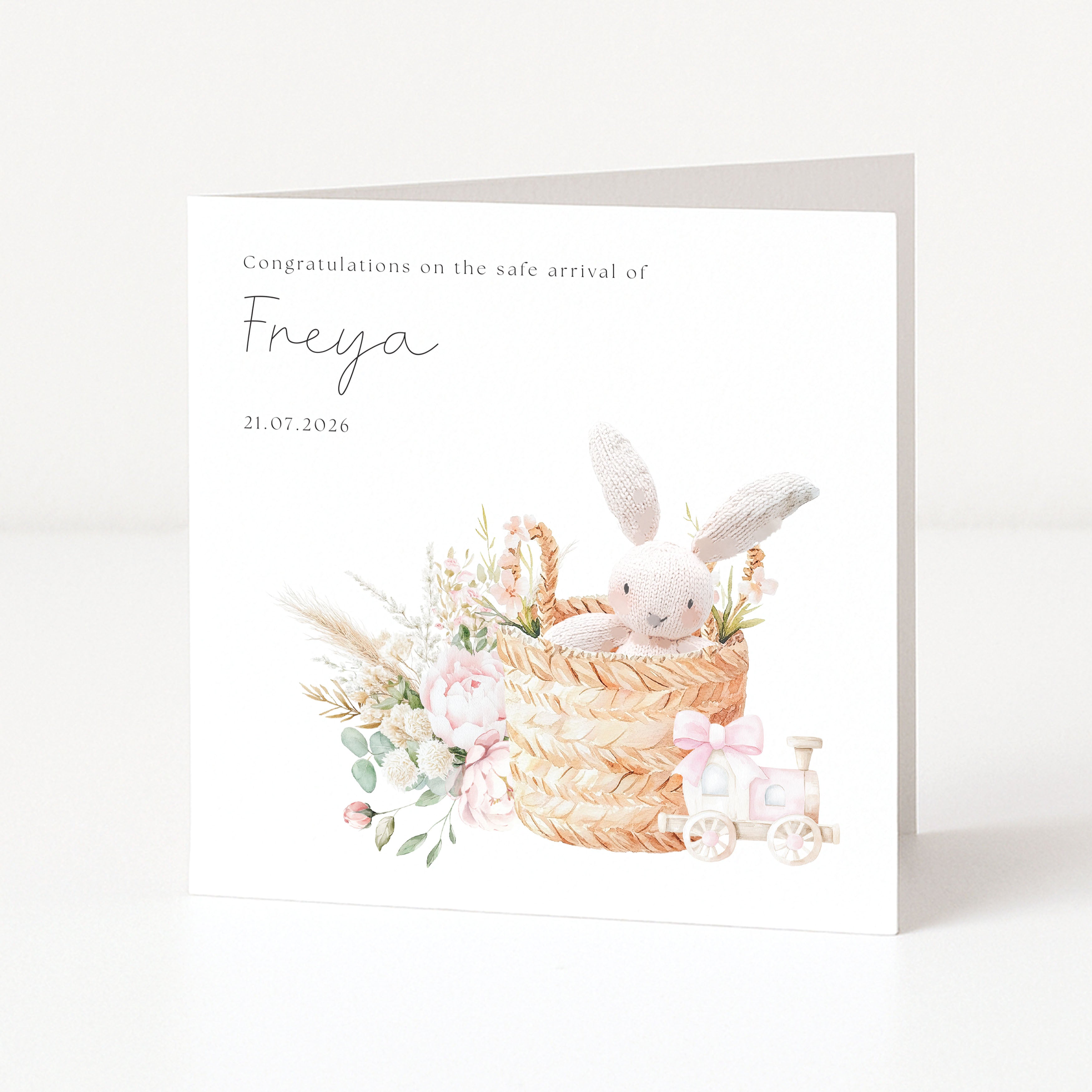 Newborn baby card with a bunny in a basket and floral elements on a white background