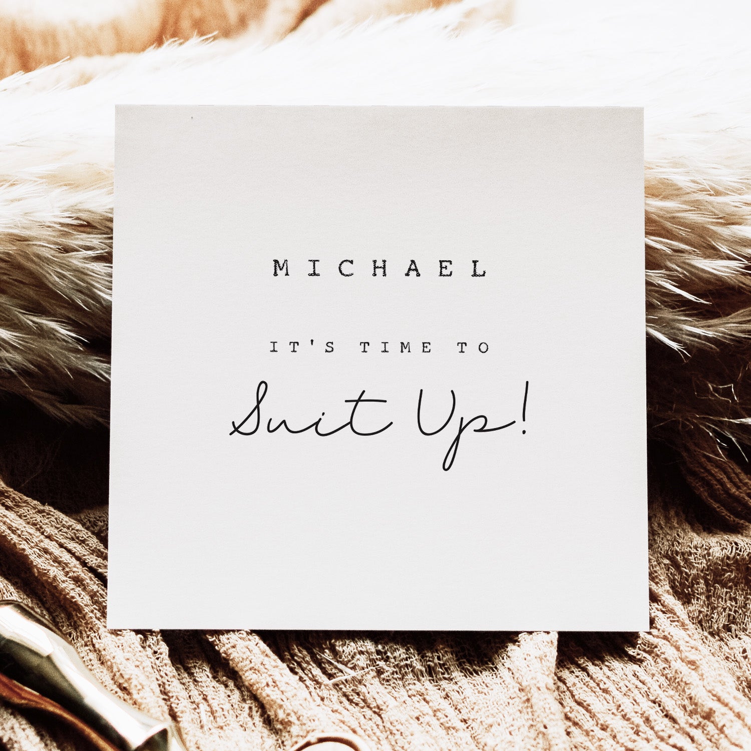 White card with text 'MICHAEL IT'S TIME TO Suit Up!' on a textured brown surface