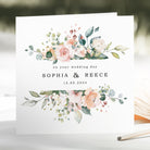 pink and white floral wedding date card with on your wedding day on the front with blurred background