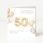 Personalised square 50th birthday card for a girlfriend featuring metallic gold foil balloon number fifty graphics, cream and gold watercolor balloons, and customisable front name text.
