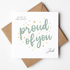 Greeting card with 'proud of you' text and stars, placed on a white background with a brown envelope.