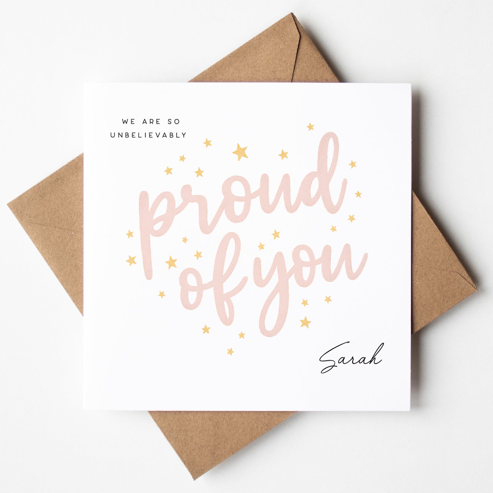 Greeting card with 'proud of you' text and a brown envelope on a white background