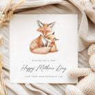 Greeting card with fox illustration and 'Happy Mother's Day' text on a textured fabric background.
