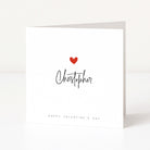 Greeting card with a red heart and 'Christopher' written on it, on a white background.
