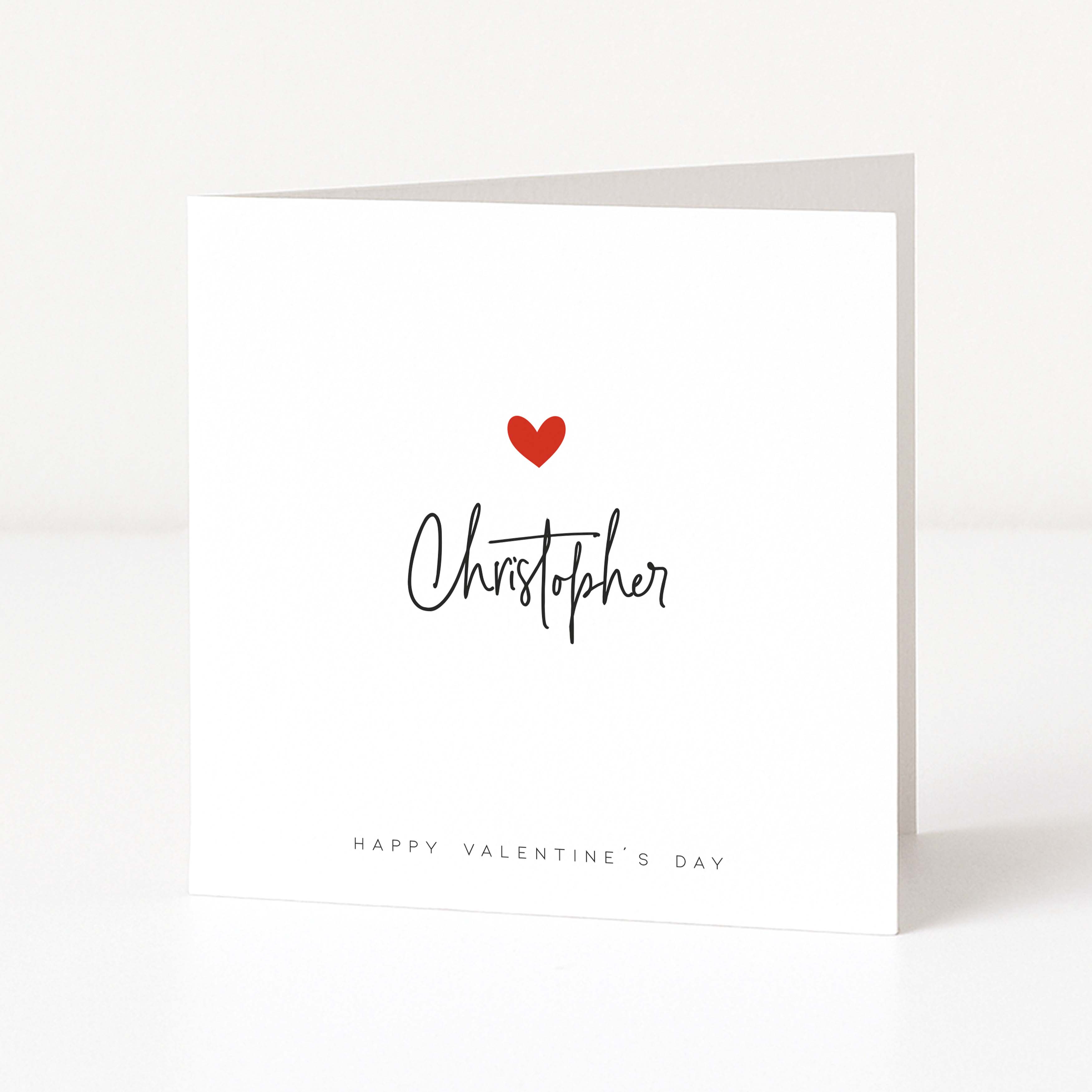 Greeting card with a red heart and 'Christopher' written on it, on a white background.