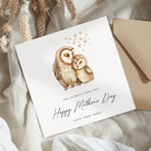Greeting card with owl illustration and 'Happy Mother's Day' text on a textured surface.