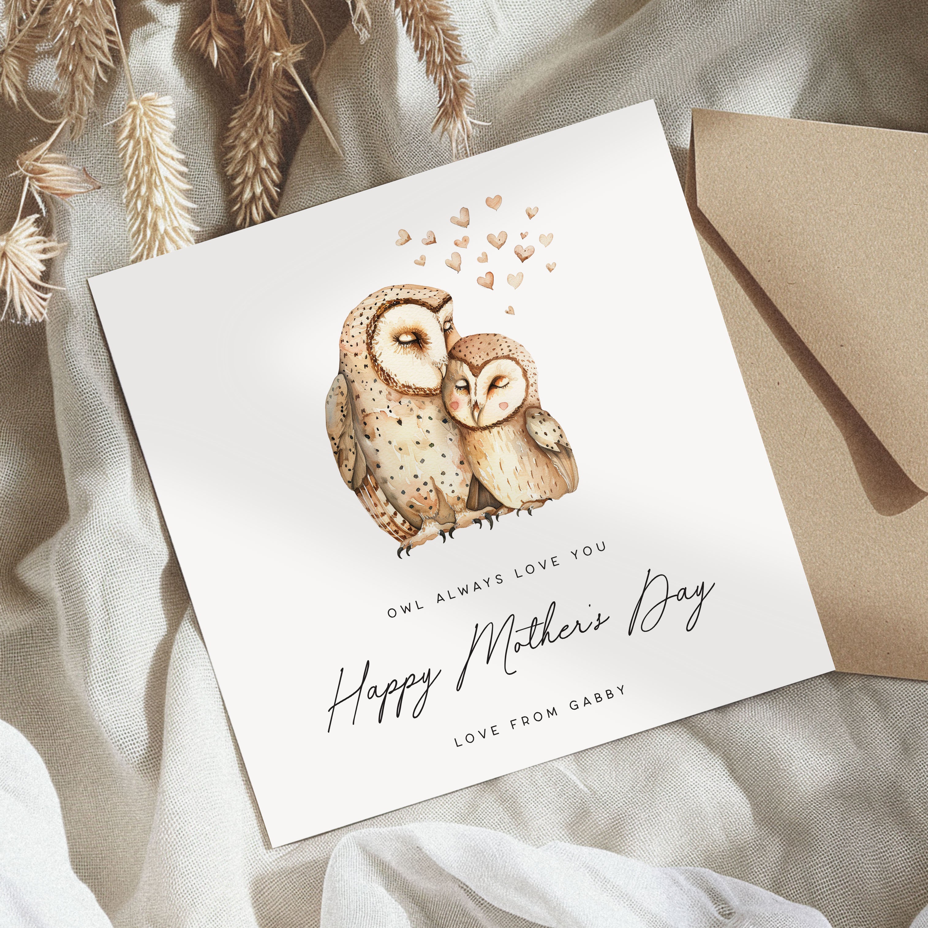Greeting card with owl illustration and 'Happy Mother's Day' text on a textured surface.